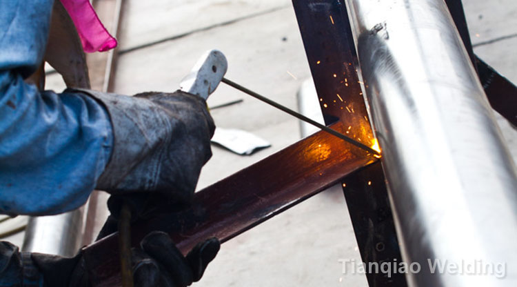 Рабочий делает искры при сварке стали